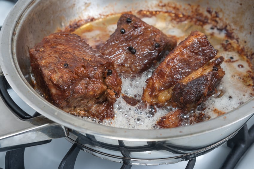 searing beef in a hot pan with oil