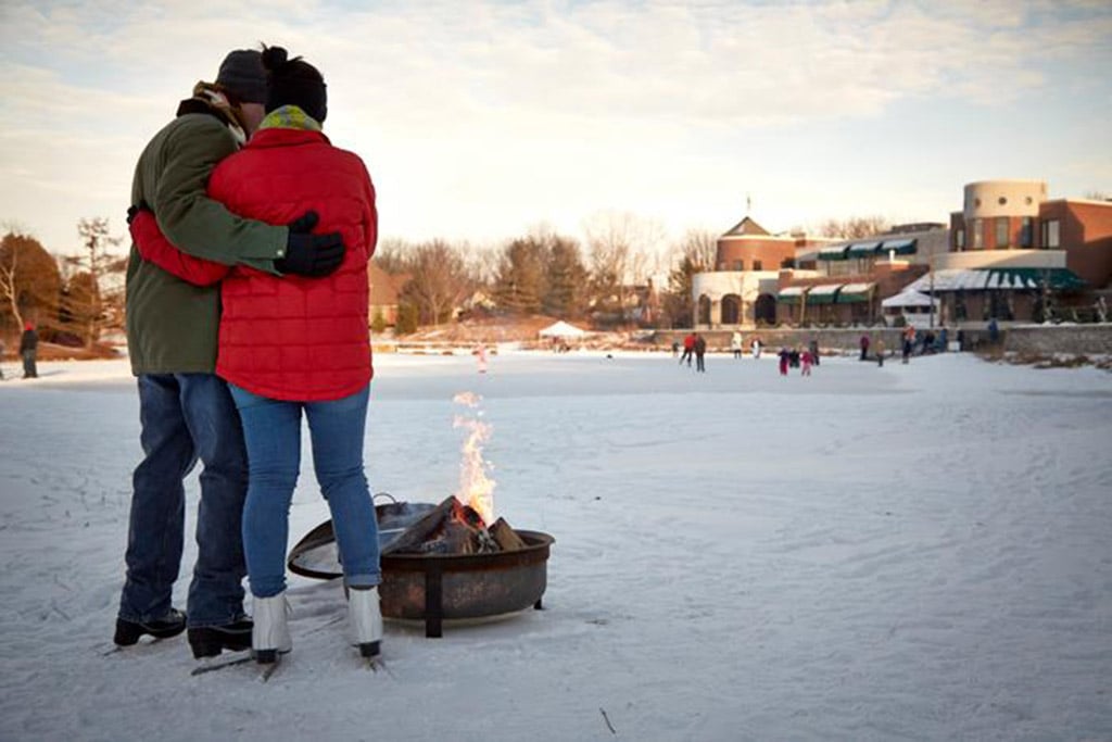 Couple warming up by the fire after ice skating at The American Club in Kohler, Wisconsin