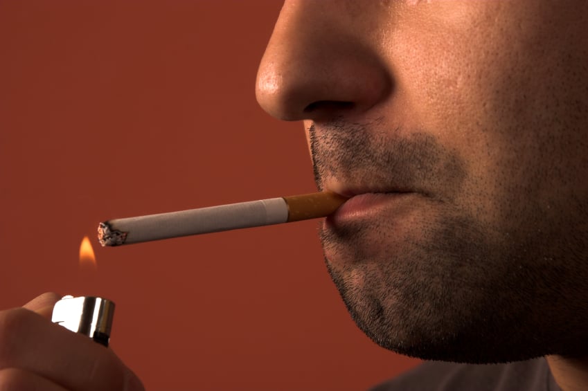 close up of a man lighting a cigarette to smoke