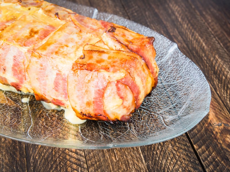glass plate with meatloaf wrapped in bacon