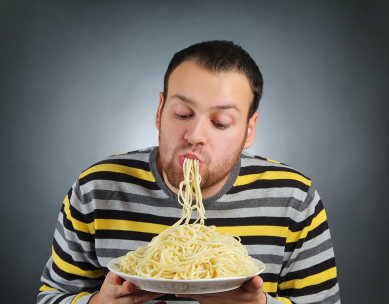 man slurping a huge plate of spaghetti without a fork