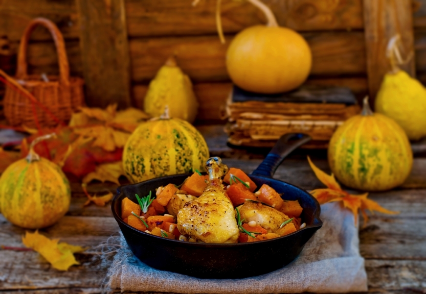 cast-iron skillet filled with roast chicken and pumpkin