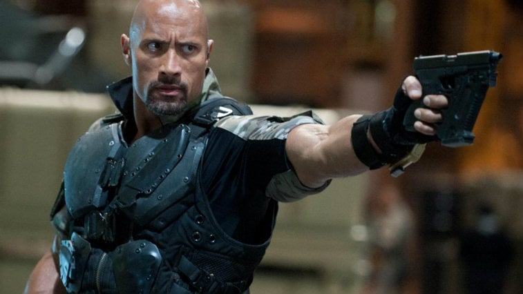 Dwayne Johnson is wearing body armor and is pointing a gun in Fast Five.