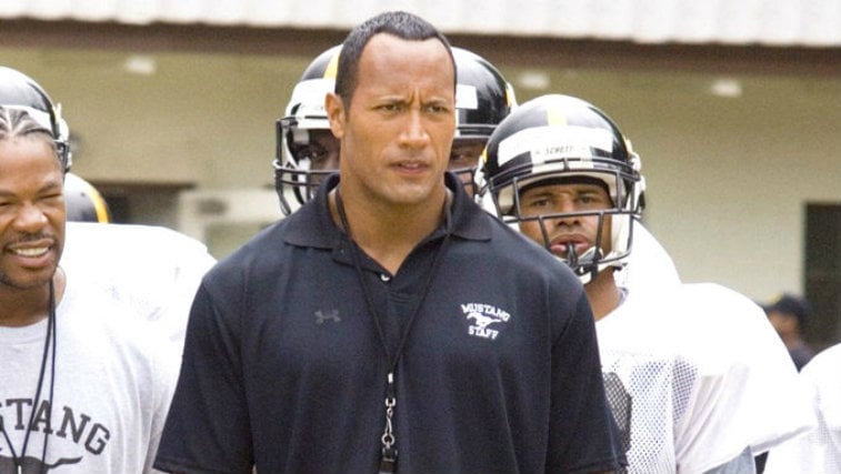 Dwayne Johnson is on the sidelines and is dressed as a football coach in Gridiron Gang.