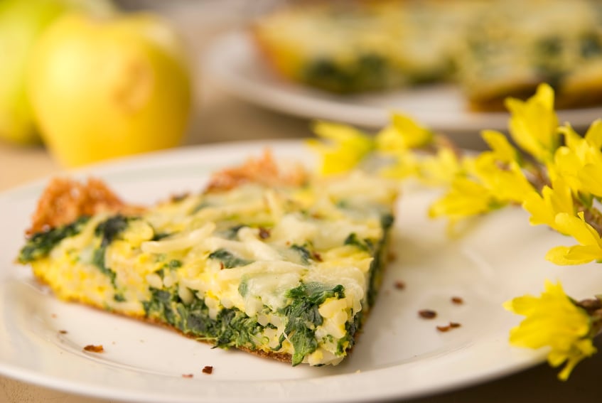 white plate with a slice of spinach and spaghetti frittata