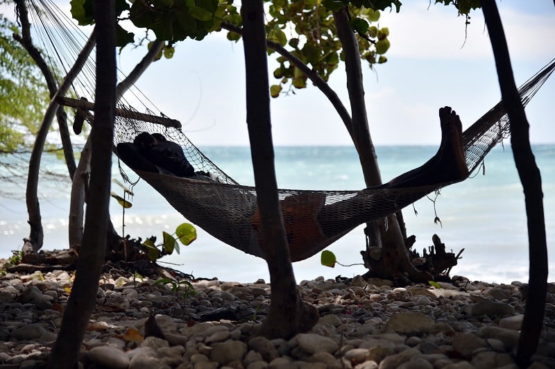 A man sleeps in a hammock close to the beach in the commune of is Anse-a-Pitres, in the South East Department of Haiti, on October 14, 2015 A man sleeps in a hammock close to the beach in the commune of is Anse-a-Pitres, in the South East Department of Haiti, on October 14, 2015