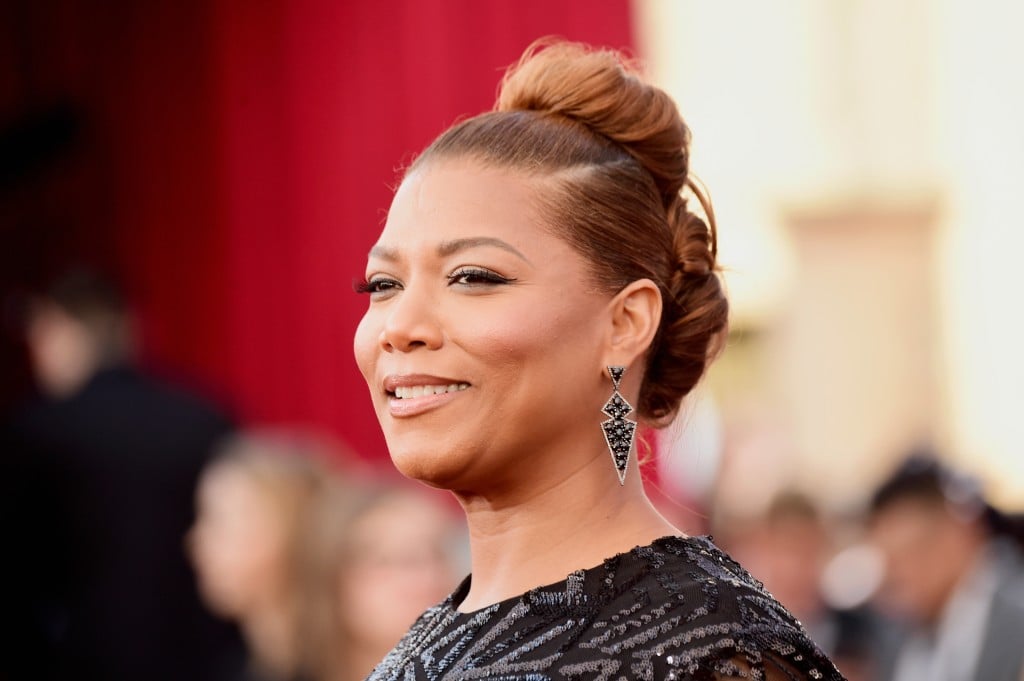 Queen Latifah is smiling on the red carpet.