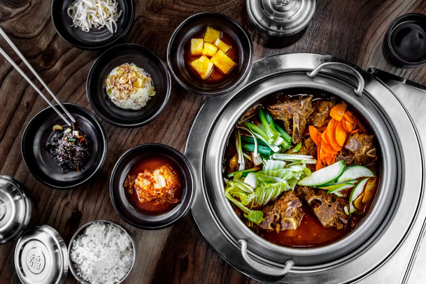 korean hot pot soup with scallions, carrots, an cucumbers
