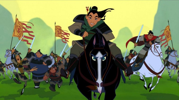 Mulan riding a black horse while leading an army.
