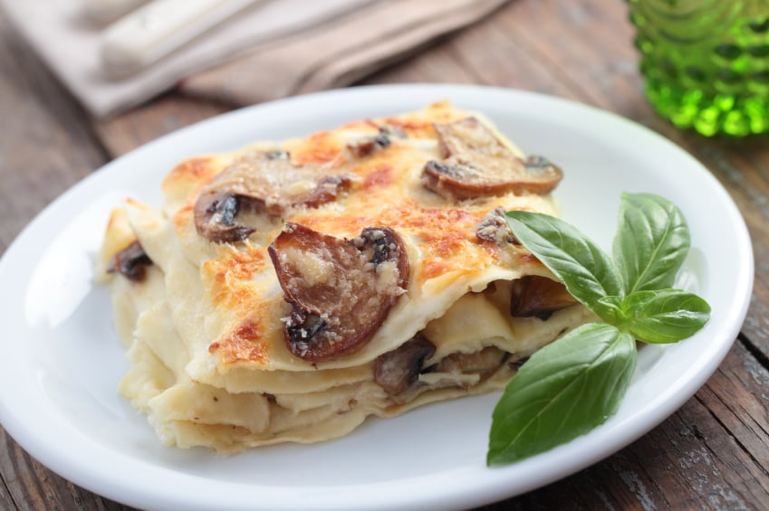 white plate with a slice of mushroom and cheese lasagna