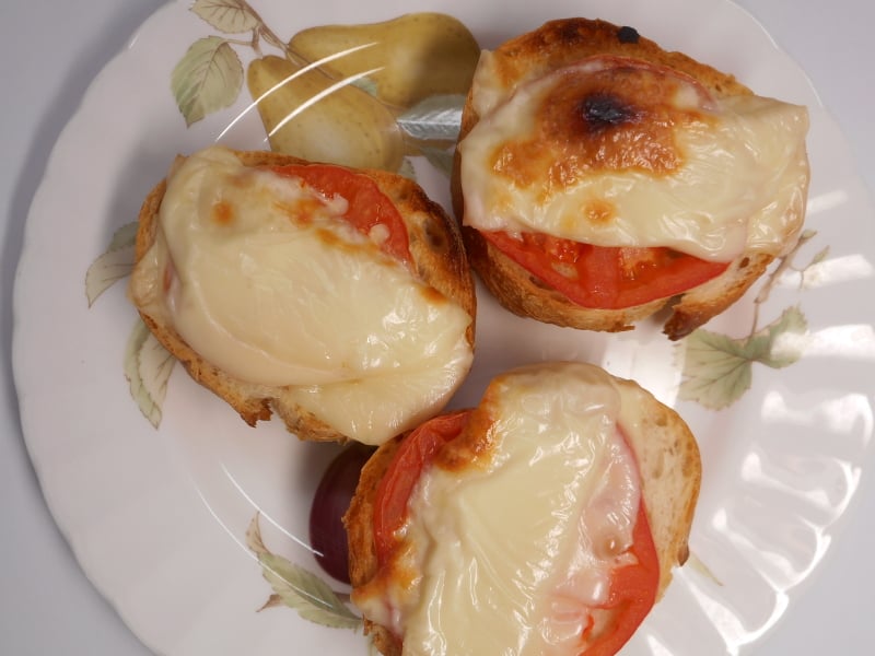 plate of open-face sandwiches with tomatoes and melted cheese on toast