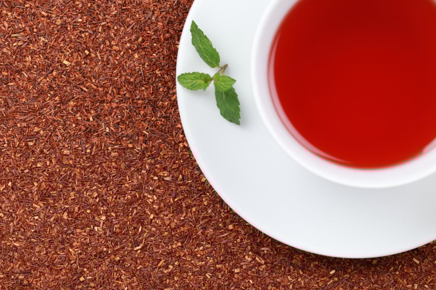 cup of rooibos tea with a sprig of lemon balm