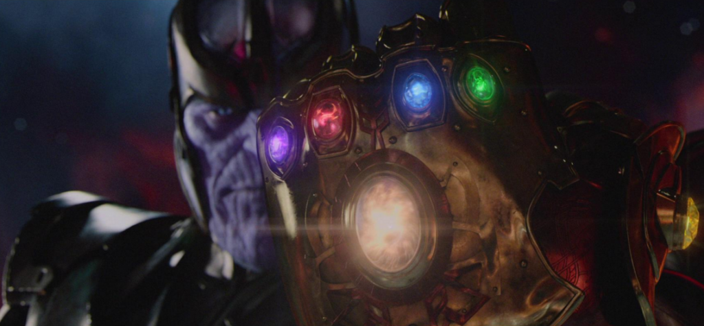 Thanos looking at the Infinity Guantlet with four stones in it