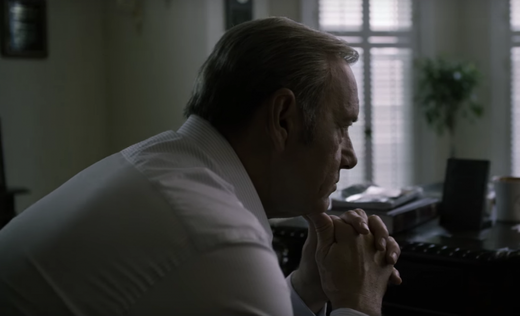 Frank leans his chin in his hands in House of Cards Frank leans his chin in his hands in House of Cards