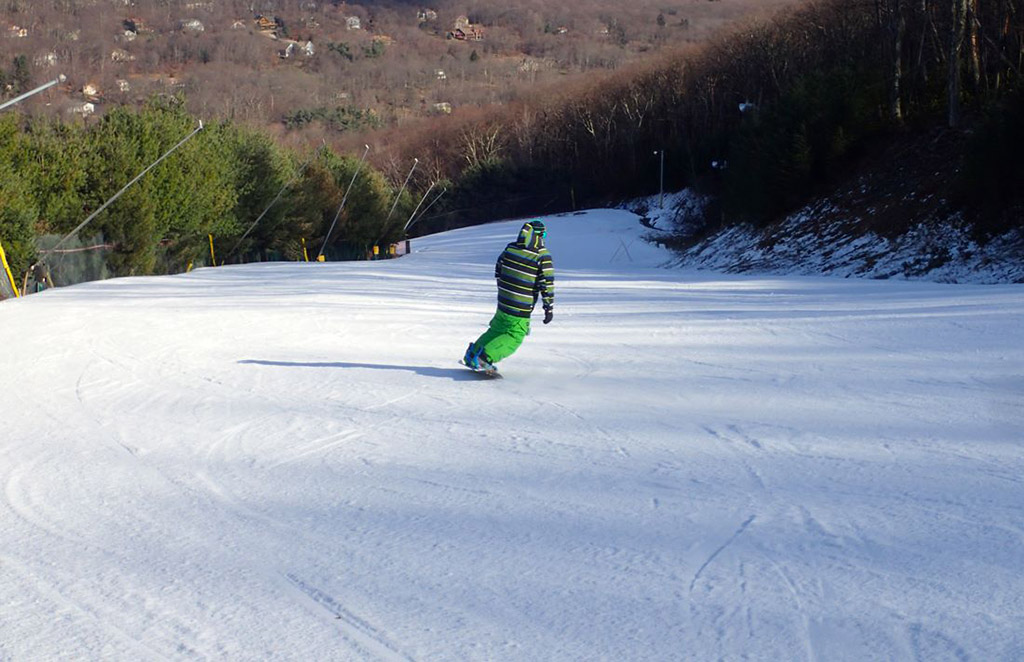 snowboarder gliding down mountain at Camelback Mountain Resort in Tannersville, Pennsylvania