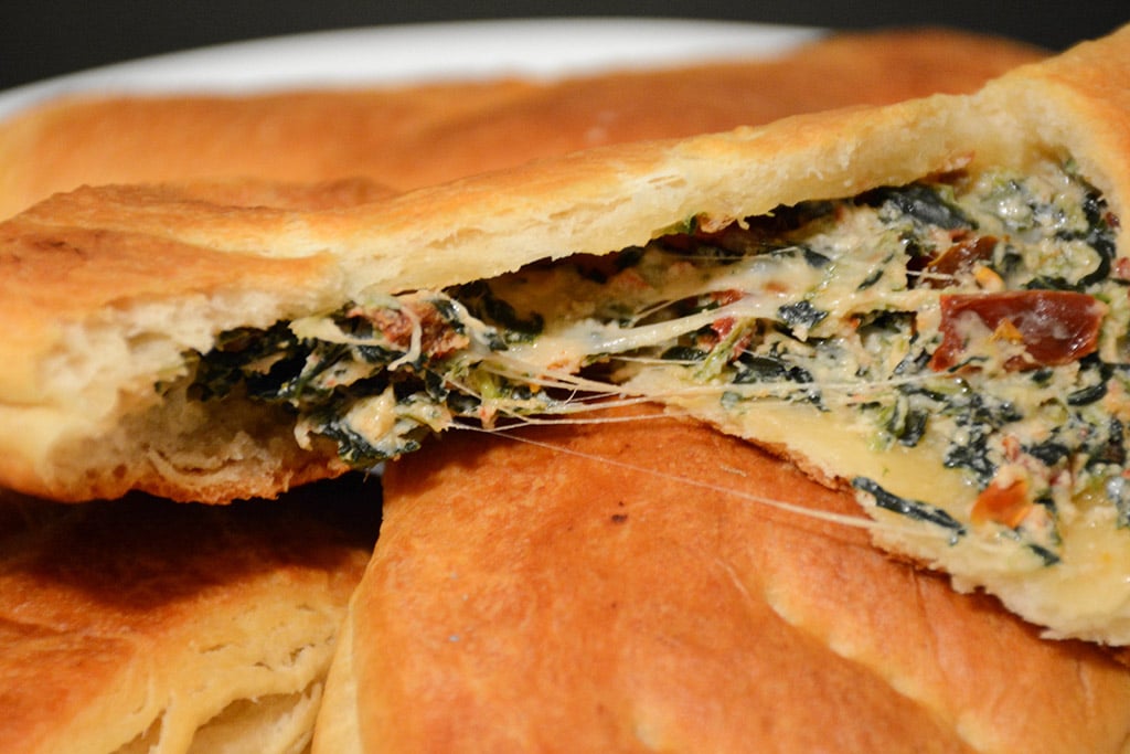 cheesy spinach pocket being torn open