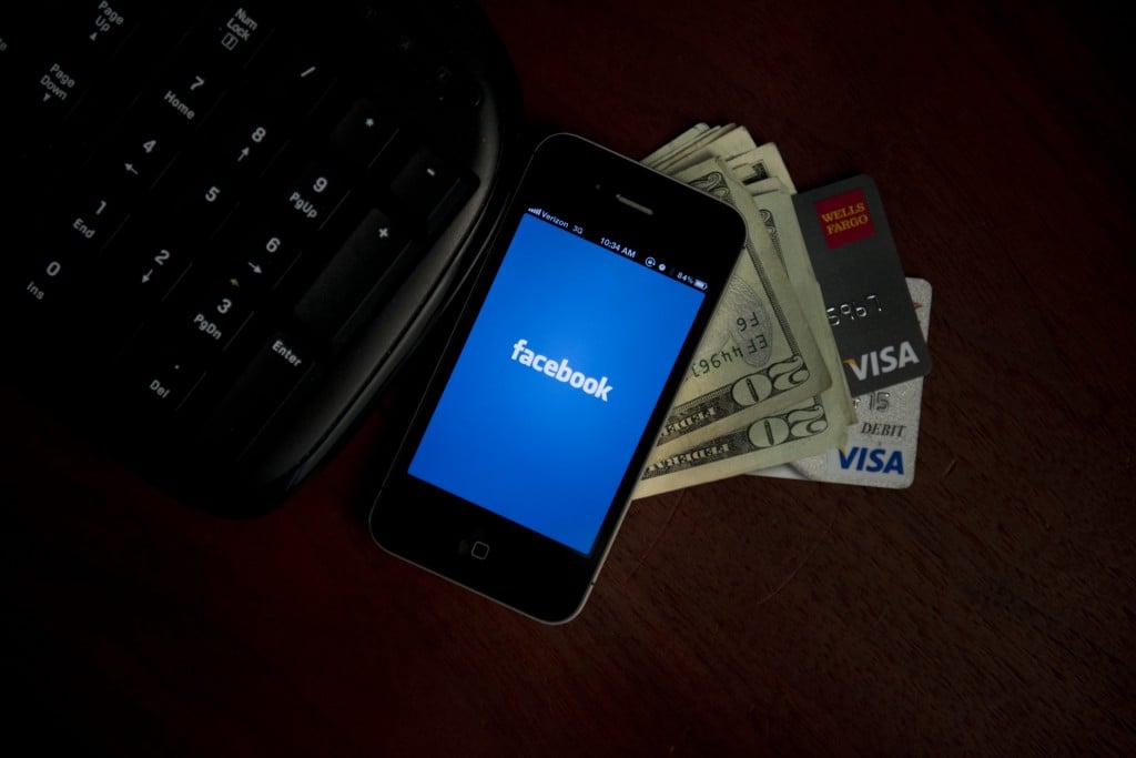 Phone showing Facebook and money with credit cards