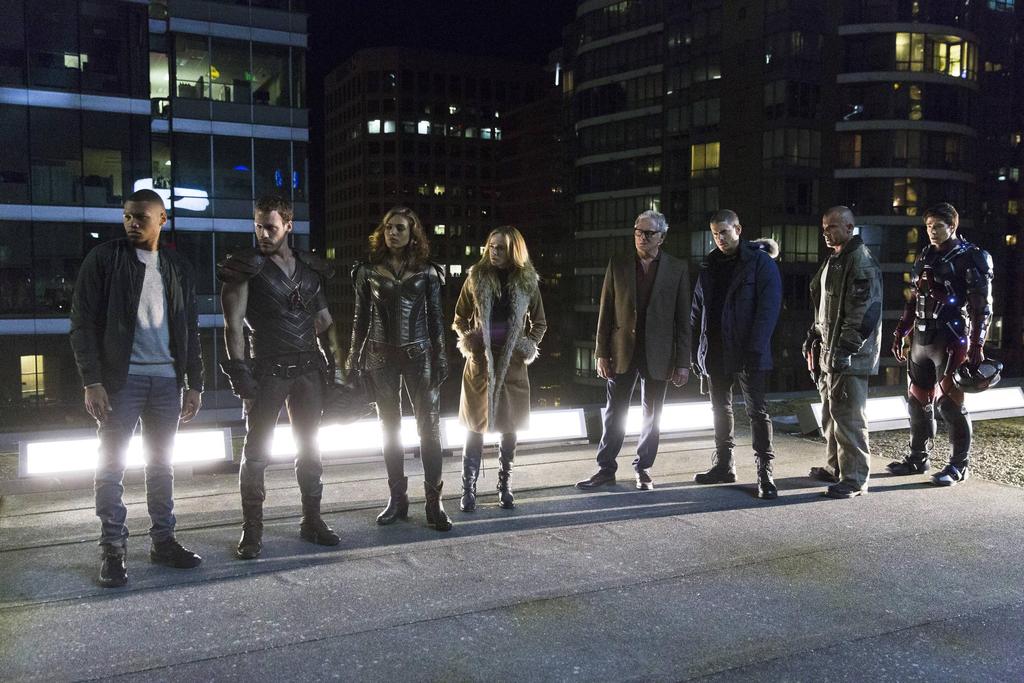 The cast of The CW's Legends of Tomorrow stands on a rooftop