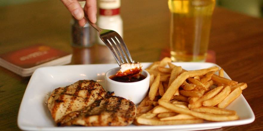 A diner dips his entree in a tangy, zesty sauce