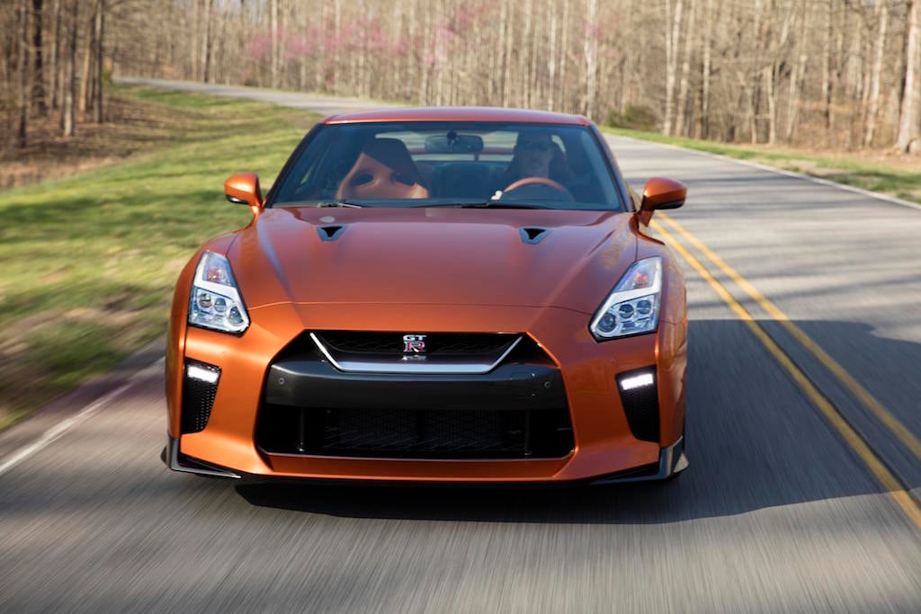 The 2017 GT-R's exterior receives a thorough makeover. The new V-motion grille, one of Nissan's latest design signatures, has been slightly enlarged to provide better engine cooling and now features a matte chrome finish and an updated mesh pattern. A new hood, featuring pronounced character lines flowing flawlessly from the grille, has been reinforced to enhance stability during high-speed driving. A freshly designed front spoiler lip and front bumpers with finishers situated immediately below the headlamps give the new GT-R the look of a pure-bred racecar, while generating high levels of front downforce.