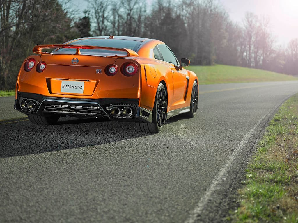 The 2017 GT-R's exterior receives a thorough makeover. The new V-motion grille, one of Nissan's latest design signatures, has been slightly enlarged to provide better engine cooling and now features a matte chrome finish and an updated mesh pattern. A new hood, featuring pronounced character lines flowing flawlessly from the grille, has been reinforced to enhance stability during high-speed driving. A freshly designed front spoiler lip and front bumpers with finishers situated immediately below the headlamps give the new GT-R the look of a pure-bred racecar, while generating high levels of front downforce.