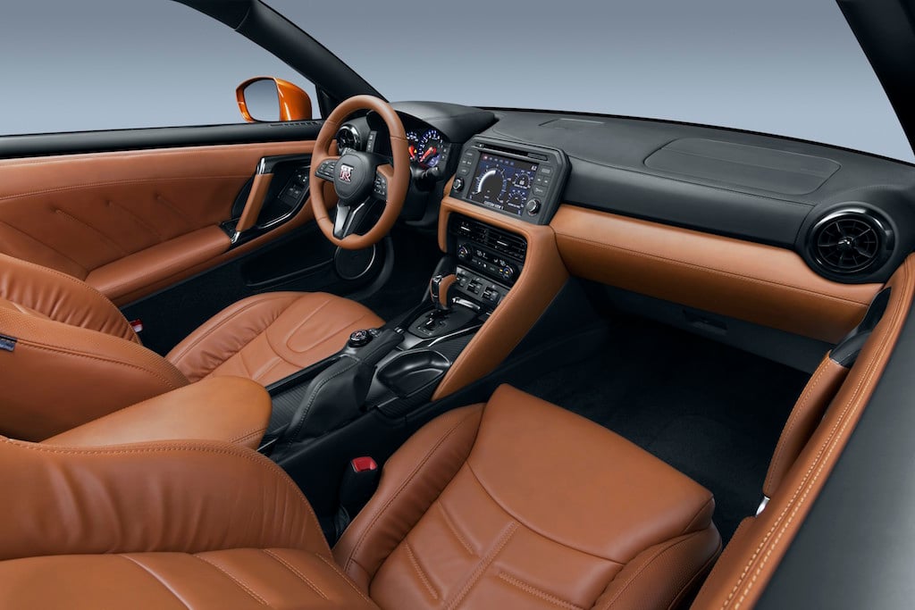 The 2017 GT-R's exterior receives a thorough makeover. The new V-motion grille, one of Nissan's latest design signatures, has been slightly enlarged to provide better engine cooling and now features a matte chrome finish and an updated mesh pattern. A new hood, featuring pronounced character lines flowing flawlessly from the grille, has been reinforced to enhance stability during high-speed driving. A freshly designed front spoiler lip and front bumpers with finishers situated immediately below the headlamps give the new GT-R the look of a pure-bred racecar, while generating high levels of front downforce.