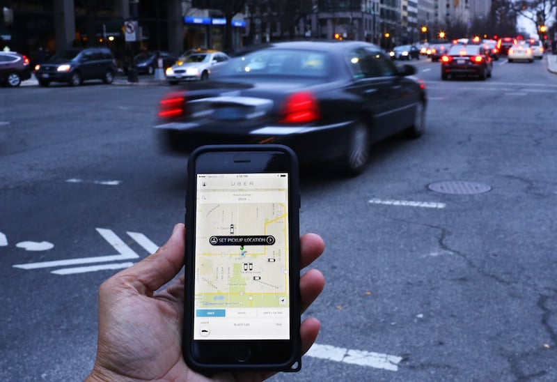 The Uber app shown as cars drive by