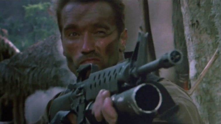 Arnold Schwarzenegger holds up a rifle in Predator
