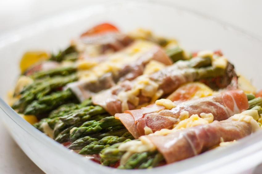 Prosciutto wrapped asparagus in a white tray