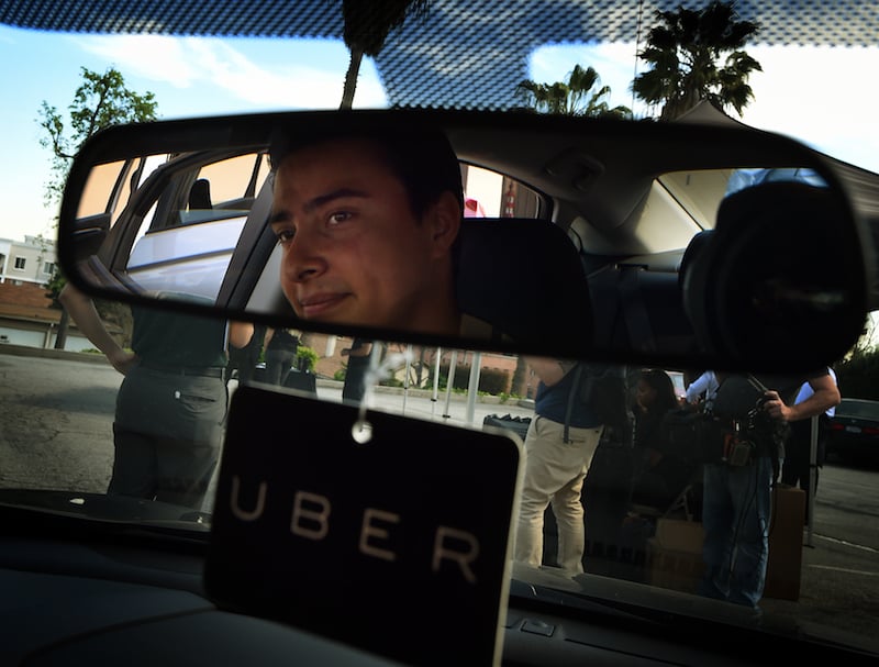 Jesse Vega checks a vehicle at the first of Uber's 'Work On Demand' recruitment events to recruit 12,000 new Uber drivers