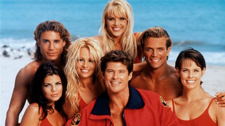 El reparto de Baywatch sonriendo y posando en la playa