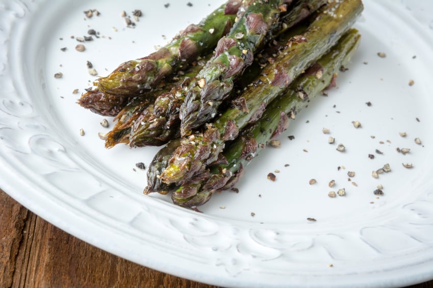 roasted asparagus with pepper on a white plate