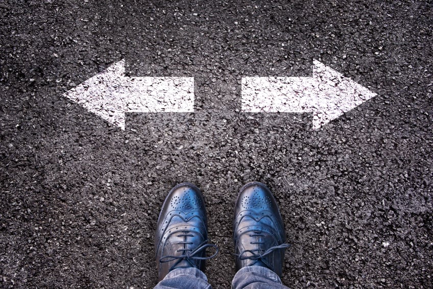 feet in front of two arrows painted on the road
