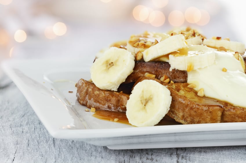 French toast topped with bananas, toasted pecans and creamy caramel