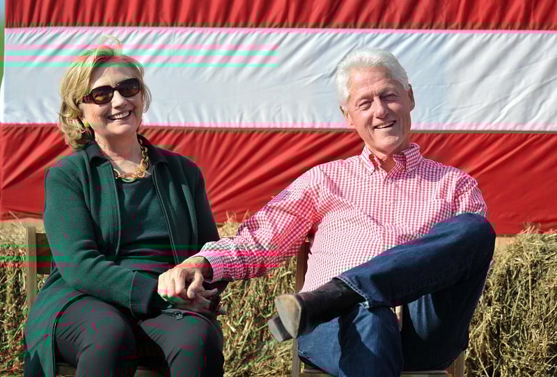 Bill and Hillary Clinton holding hands at a steak fry in Iowa