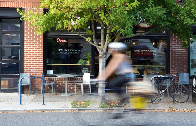 PORTLAND, OREGON - OCTOBER 6: A bicycle commuter rides past a Stumptown Coffee location on SE Division Street on October 6, 2015 in Portland, Oregon. Stumptown's owner and founder Duane Sorenson has confirmed that the company will be acquired by Peet's Coffee & Tea, according to published reports. Stumptown, which reportedly will operate independently after the aqcquisition, operates 10 stores in Portland, Seattle, New York and Los Angeles. (Photo by Craig Mitchelldyer/Getty Images)