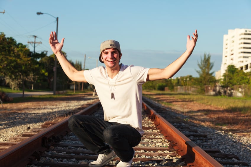 man dressed in white t-shirt, jeans, and hat