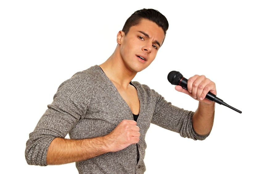 young man posing and singing on a microphone