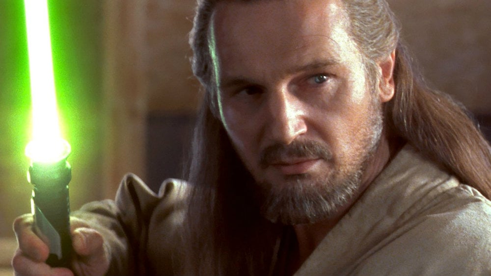 Liam Neeson holds his lightsaber up in The Phantom Menace