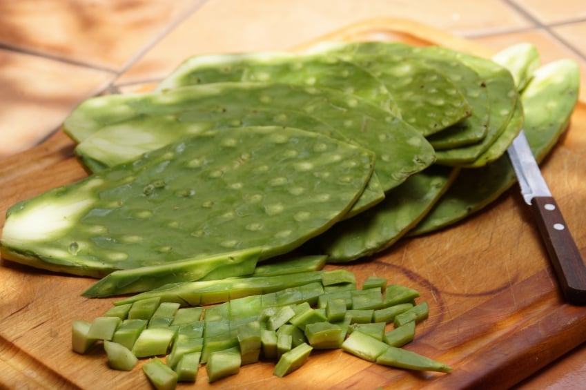 Nopales on a wooden cutting board with knife