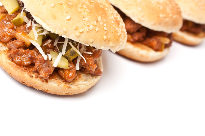 three sloppy Joes with shredded cabbage and pickles