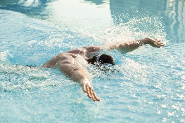 man swimming butterfly stroke in a pool