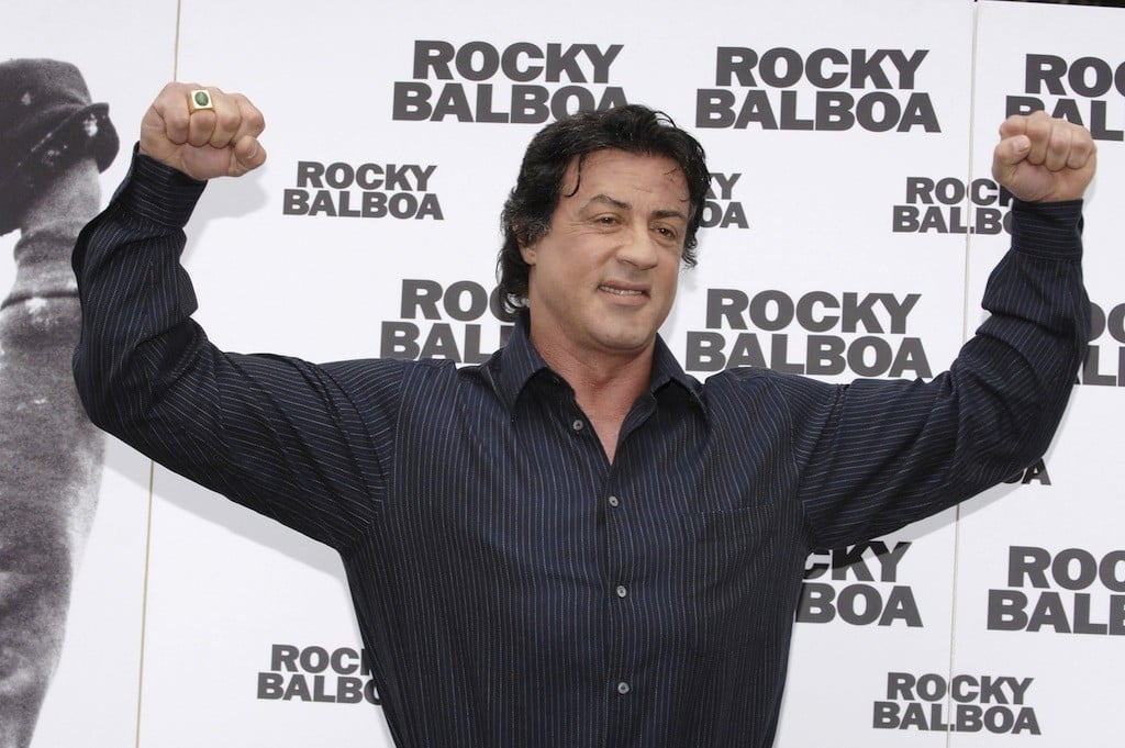 Sylvester Stallone flexes both arms. Sylvester Stallone flexes both arms.
