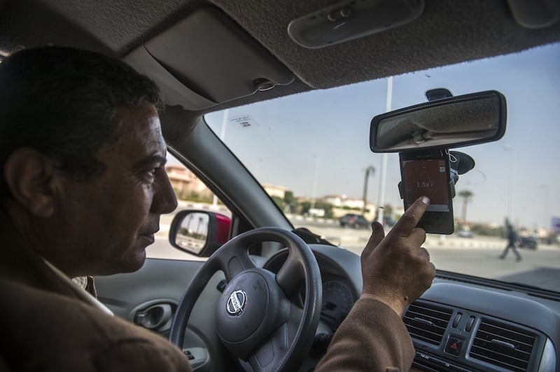 An Uber driver in Cairo checks a map on his smartphone