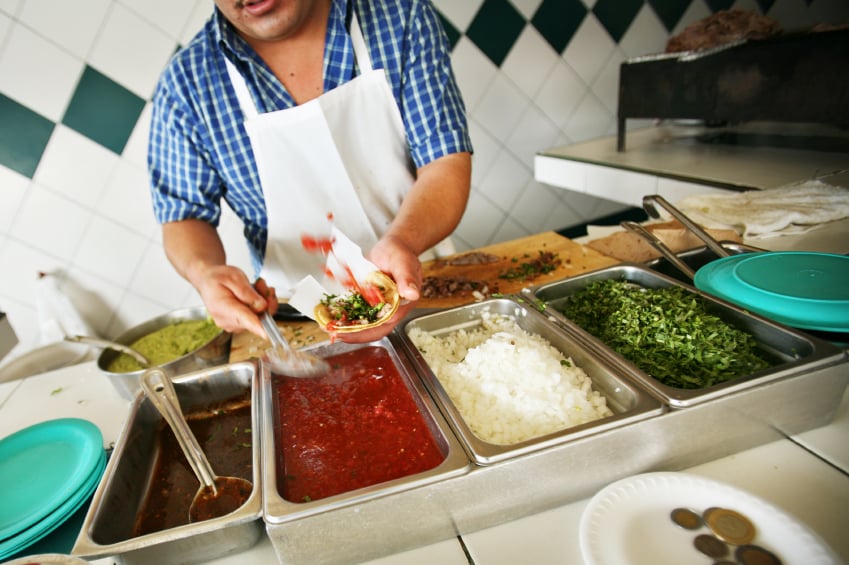 Worker Making Tacos in restaurant kitchen