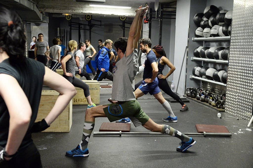 group of athletes doing lunges at a CrossFit facility in France
