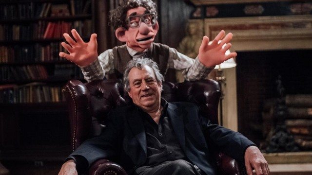 Terry Gillam sits with a puppet on the set of 'Boom Bust Boom'