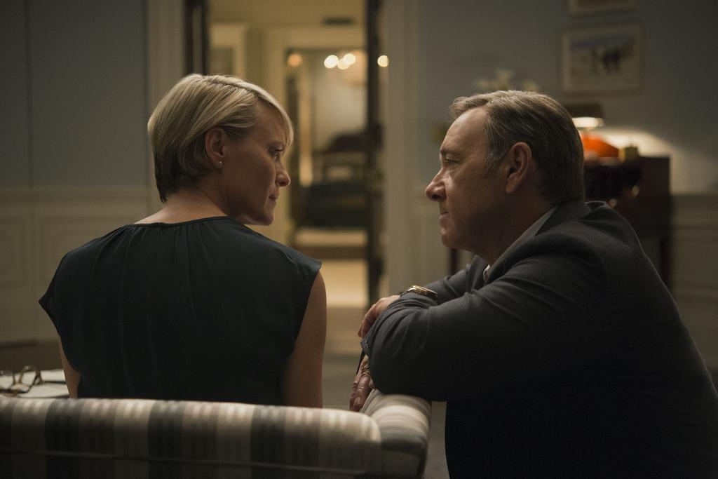 Claire sits on a chair while Frank kneels next to her in House of Cards Claire sits on a chair while Frank kneels next to her in House of Cards