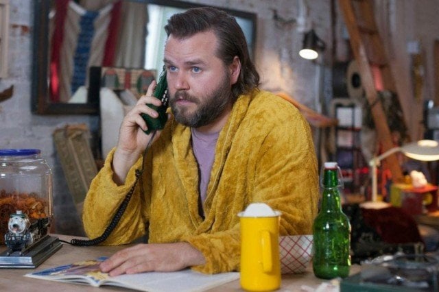 Kevin (Tyler Labine) takes a phone call in a scene from Hulu's supernatural comedy, 'Deadbeat'