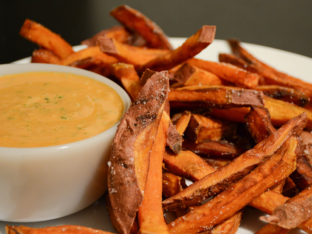 plate of sweet potato fries with a side of curry-peanut dip